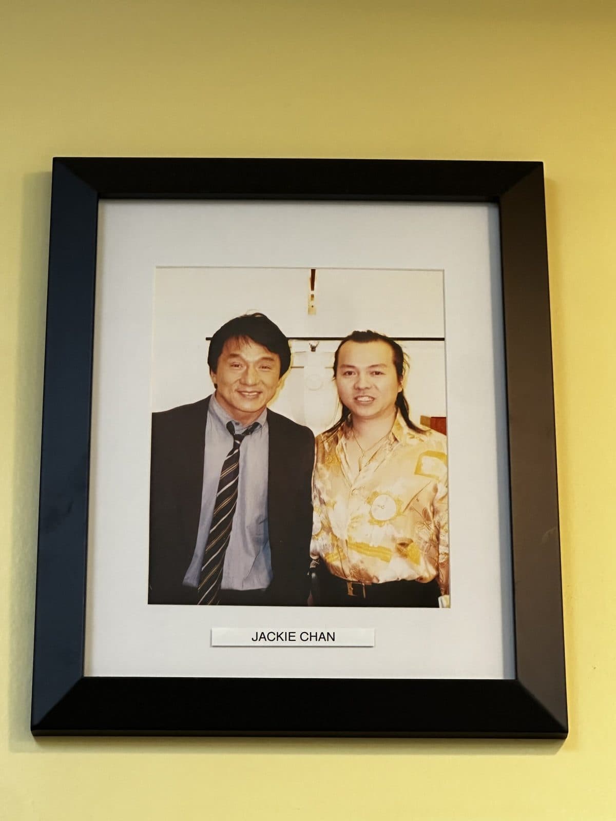 Framed photo on the salon wall, labeled Jackie Chan