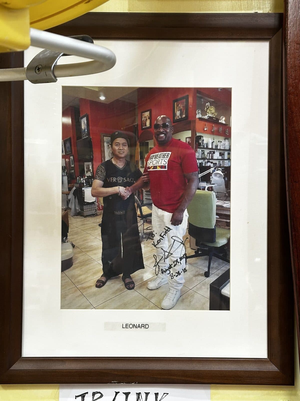 Framed signed photo on the salon wall, labeled Leonard